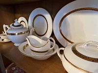 Shelf view showing teapot, gravy boat on underplate, large platter, creamer and tureen.