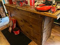 Full view of pine wood bar counter with knots and rope detail on edge, items on top not included