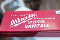Close-up photo of red Milwaukee metal carrying case lid showing Heavy-Duty, High Performance Super Sawzall branding
