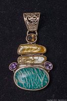 Close-up front view of the large pendant showing detailed stones and silver work.