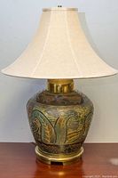 Full view of the vintage table lamp showing ceramic embossed floral base with cream fabric shade