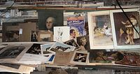 Wide view of table covered with assorted photographs, art prints, film poster and paper ephemera