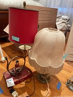Both lamps together showing red shade with fox figurine lamp and beige fabric fringed shade lamp
