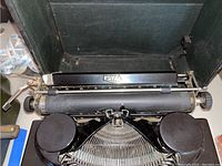 Front view of black Royal typewriter showing keys and platen in original case.