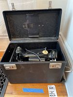 Singer sewing machine and accessories inside open carrying case