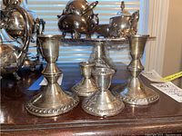 Four sterling silver candle holders shown with rope border decorations.