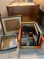 Wooden frame 21x15 inch partially visible on table next to smaller frames in cardboard box