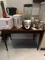 Full view of the table showing brown laminate top with items on it (not included in sale)