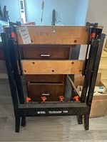 Front view of the Black & Decker Workmate 150 portable workbench in folded position with visible wooden jaws and black metal frame