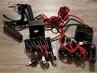 Red resistance bands with black mounting blocks and foam-padded handles arranged on a flat surface.