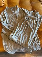 Gray Givenchy track suit consisting of a half-zip top and matching pants laid out on a surface.