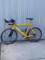 Full left side view of bike showing yellow Trek Hilo frame, black carbon fork and clip-on aero bars