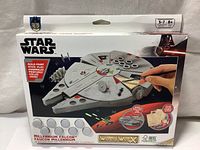 Front view of the sealed Wood Worx Star Wars Millennium Falcon build and paint kit box with image of model and paint pots.