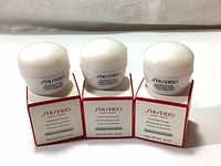 Front view of three cream jars and boxes showing product name and size