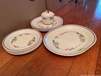 All serveware items arranged including platters, plates, and sugar bowl