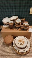 Overview of bowls, cups, side plates stacked on cardboard box