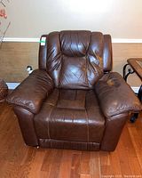 Front view of the brown leather electric recliner armchair showing padded cushions and armrests.