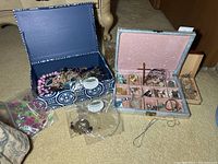 Boxes with assorted costume jewelry pieces, necklaces, bracelets, and loose parts in plastic bags.