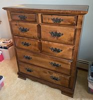 Front view of the Kincaid wooden dresser showing six drawers and metal handles with visible scratches on surface.