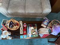 Top view of model cars, puzzles, yarn, candle, and games arranged on a wooden coffee table