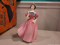 Front view of Royal Doulton 'Camellia' figurine showing pink dress and bonnet detail