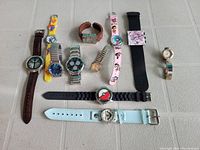 Full view showing all 11 watches with various bands and character faces