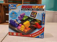 Front view of the sealed box of Rush Hour Traffic Jam Logic Game by ThinkFun showing colorful cars and trucks on a grid and labeling 40 challenges from beginner to expert.