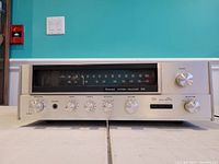 Front view of Sansui 331 stereo receiver showing tuning dial, rotary knobs for speakers, bass, treble, balance, volume, input selector, headphone jack, and sliders.