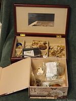 Photo of two boxes of assorted jewelry items including bracelets, chains, and loose components for repair or crafts