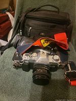 Canon AL-1 camera with Tokina lens attached, sitting on a towel with black carrying bag in the background.
