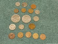 Full view of 14 coins including US Eisenhower dollars, Roosevelt dime, Washington quarter, Jefferson nickel, and various foreign coins.