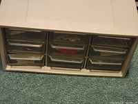 White plastic organizer with multiple small transparent drawers.