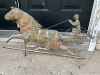 Full view of the copper weathervane showing horse, carriage and driver mounted on rods