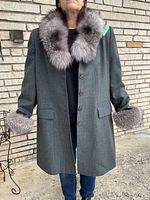 Full front view of grey wool coat on model showing length, button closure, fur trim at collar and cuffs