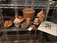 Full view of all baskets, vases, medallion and print displayed on wire shelving