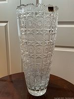 Full front view of tall cut crystal vase showing geometric pattern and scalloped rim