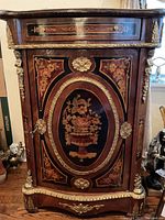 Full front view of Louis XV style commode showing single drawer, cabinet door and ormolu mounts