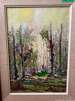 Full view of framed painting showing abstract forest scene with palette knife texture