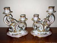 Front view of both candelabras on wooden surface against wall