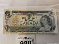 Single 1973 one-dollar bill front view showing Queen Elizabeth II portrait and serial number ECP7612550.