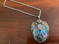 Full view of pendant necklace laid flat on wood surface