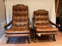 Front view of large and small cognac vinyl tufted lounge chairs showing button tufting and frame, size difference