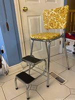 Front view of step stool showing seat, backrest, and extended steps