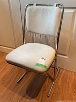 Front three-quarter view of chair showing chrome frame and vinyl seat