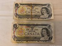 Two rubber-banded stacks of banknotes displayed face up on table