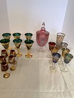 Overall arrangement of pink urn centered among three groups of coloured stem glasses