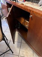 Wood credenza with two doors open showing interior shelves and storage space.