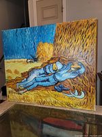 Side angle view of the oil painting showed the resting farmer in blue with prominent golden haystack and a deep blue sky.
