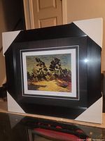 Framed artwork showing the print in black matted frame with protective corners.