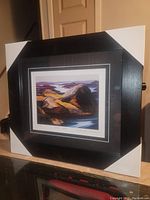Front view of black framed print with protective corner covers